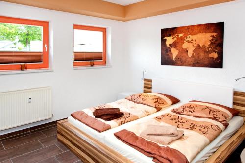 two beds in a room with two windows at Ferienwohnung Familie Leinweber in Waren