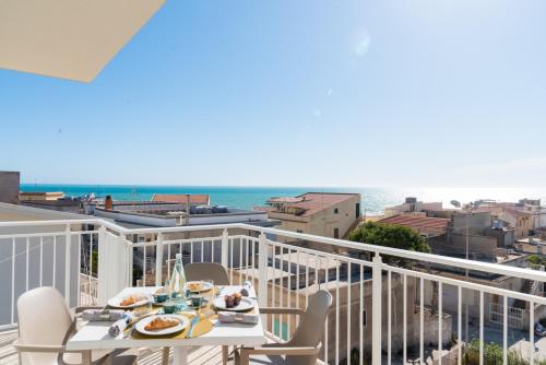 a balcony with a table and chairs and the ocean at Cava D'ALiga in Cava dʼAliga