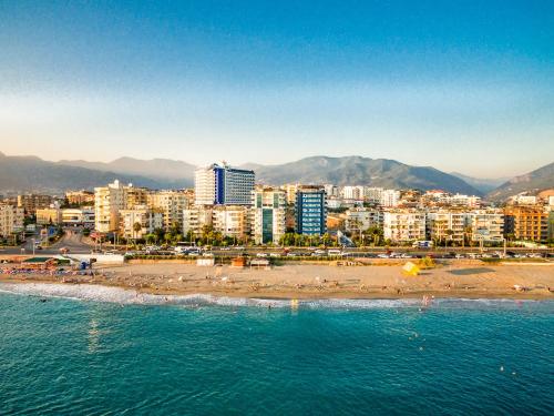 a city with a beach and buildings and the ocean at Arsi Blue Beach Hotel in Alanya