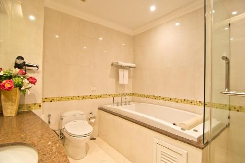 a bathroom with a tub and a toilet and a sink at LK Residence in Pattaya Central