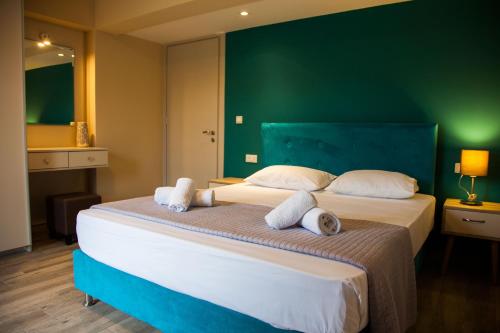 a bedroom with two beds and a green wall at Paporas Apartments in Svoronata