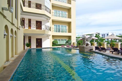 a swimming pool in front of a building at LK Residence in Pattaya Central