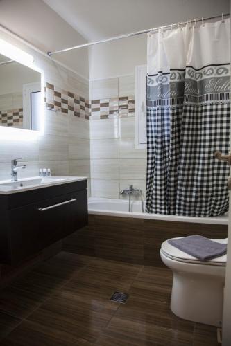 a bathroom with a tub and a toilet and a sink at Paporas Apartments in Svoronata