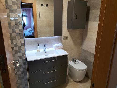 a bathroom with a sink and a toilet and a mirror at Piso turístico en Granada. Zona Palacio Deportes in Granada