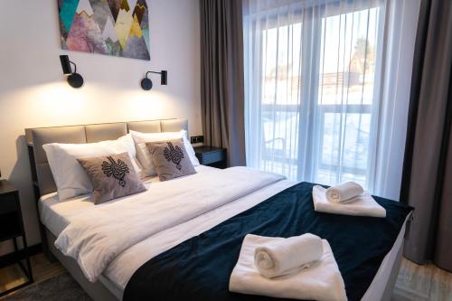 a bedroom with a large bed with towels on it at Stylchyn 90 Apartamenty nad Jeziorem Czorsztyńskim in Kluszkowce