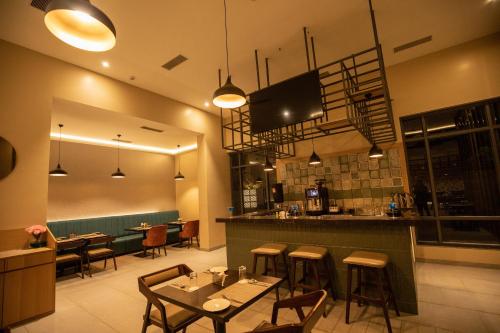 a restaurant with tables and chairs and a bar at The Vern at BLVD in Nashik