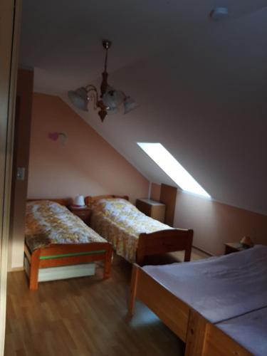 a attic room with two beds and a light at Der kleine Bauernhof keine Arbeiter zadnych pracownikow in Lubiatow