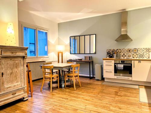 une cuisine avec une table et des chaises dans une pièce dans l'établissement Appartement de Charme de 75m², Lumineux et Calme, à Nantes