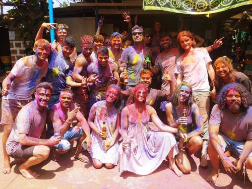 um grupo de pessoas cobertas de tinta posando para um quadro em Happy Panda Hostel Arambol Goa em Arambol