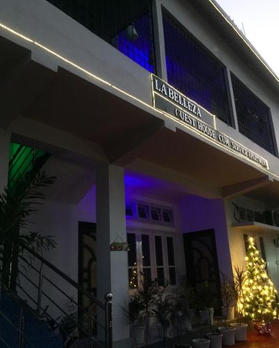 a building with a christmas tree in front of it at La Belleza Guesthouse in Guwahati