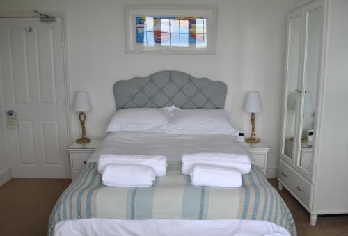 a bedroom with a bed with three towels on it at Tregony Guest House in St Ives