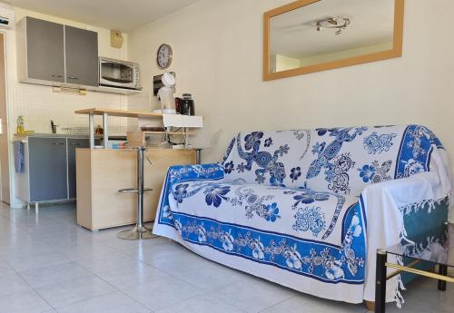 - un salon avec un canapé bleu et blanc dans l'établissement Studio calme à 50m de la plage et petite vue mer, au Grau-du-Roi