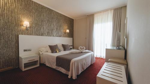 Una habitación de hotel con una cama y una ventana. en Peregrina Hotel, en Sanxenxo