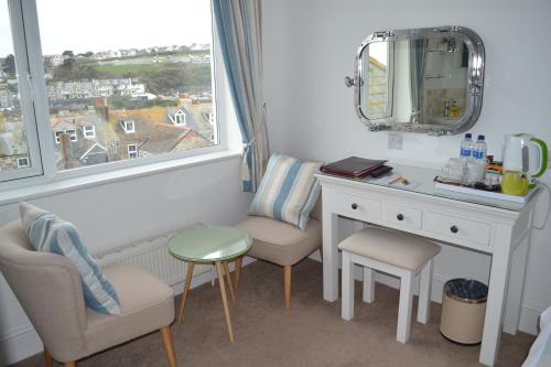 a room with a desk and a mirror and a window at Tregony Guest House in St Ives