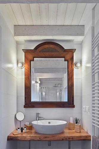 a bathroom with a sink and a mirror at Zadris 1922 Apartments & Spa in Aquiléia