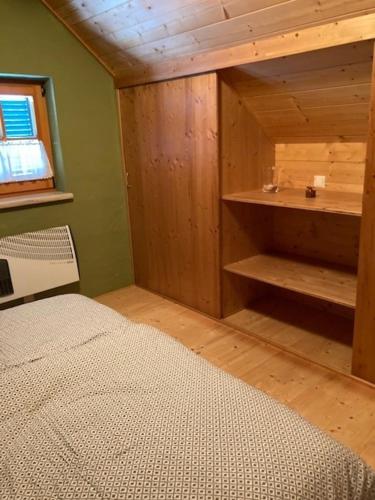 a bedroom with a bed in a wooden room at Kellerstöckl Postrumer Weinberg 49 in Kulm im Burgenland