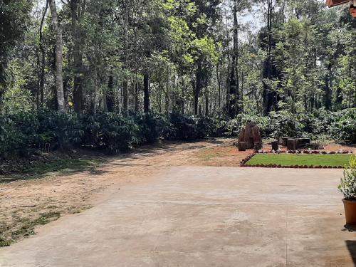 a dirt road with a statue in a park at Katihalli Estate Stays in Hassan