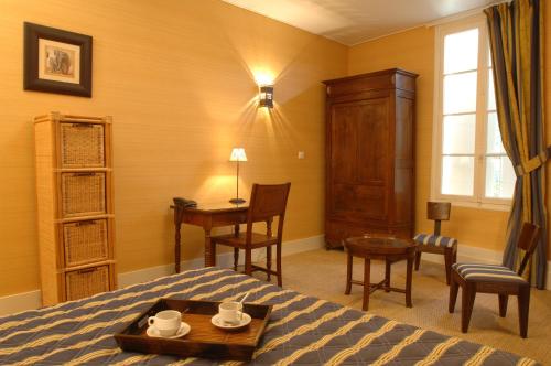 1 dormitorio con cama, mesa y escritorio en Hôtel de France, en Libourne