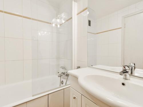ein weißes Badezimmer mit einem Waschbecken und einem Spiegel in der Unterkunft Appartement Courchevel 1650, 2 pièces, 5 personnes - FR-1-514-65 in Courchevel