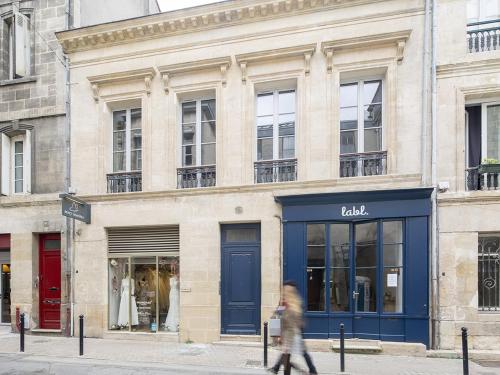 una persona che cammina davanti a un edificio di Bord'ôappart Le Cheverus a Bordeaux