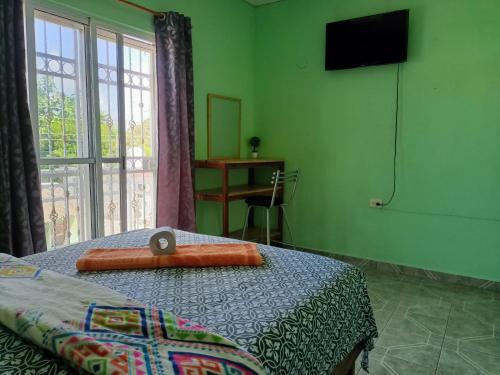 a bedroom with two beds and a television on the wall at Casa Bonzay in Bacalar