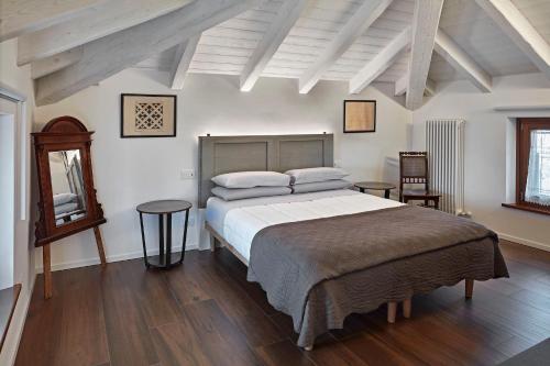 a bedroom with a large bed and a wooden floor at Zadris 1922 Apartments & Spa in Aquiléia