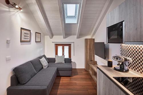 a living room with a couch and a tv at Zadris 1922 Apartments & Spa in Aquiléia