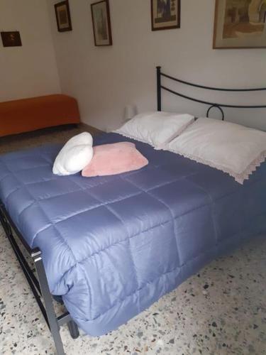 a blue bed with white pillows and a blue blanket at A casa di Adele in Caserta