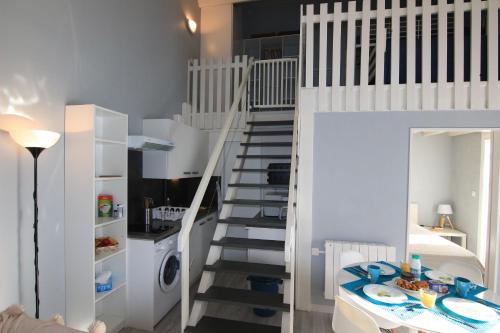 - un escalier blanc dans une petite pièce avec une cuisine dans l'établissement Appartement SOULAC SUR MER À 500 m de la plage N 3, à Soulac-sur-Mer