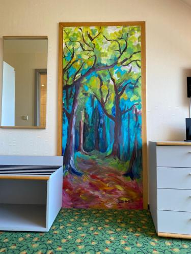 a room with a painting of a forest at Hotel am Müritz-Nationalpark in Waren
