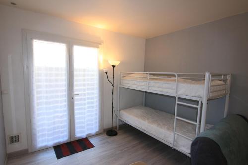 a bedroom with two bunk beds and a window at Appartement SOULAC SUR MER À 500 m de la plage N 5 in Soulac-sur-Mer