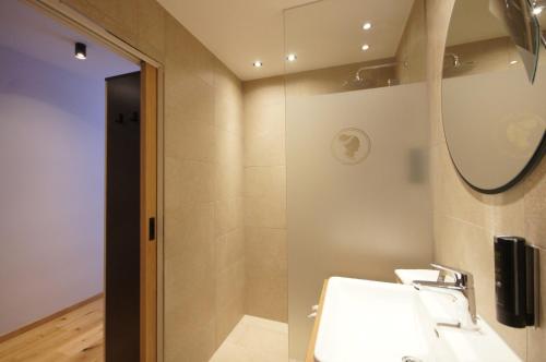 a bathroom with a sink and a mirror at Hotel Die Arlbergerin - Design & Tiroler Gemütlichkeit in Sankt Anton am Arlberg