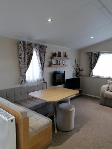 a living room with a table and a couch at Haven Devon Cliffs - Karo Place in Exmouth