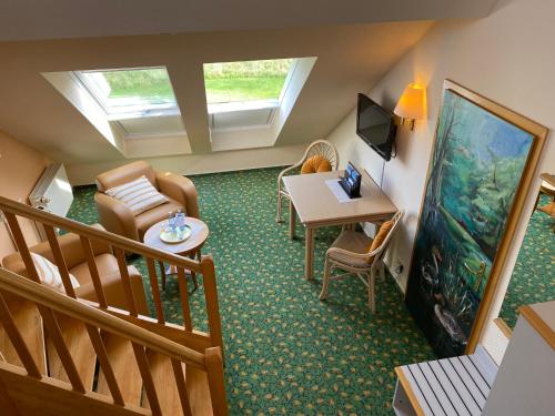 a living room with a table and chairs and an aquarium at Hotel am Müritz-Nationalpark in Waren