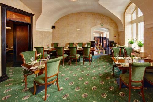 um restaurante com mesas e cadeiras num quarto em Hotel Atlas Deluxe em Lviv