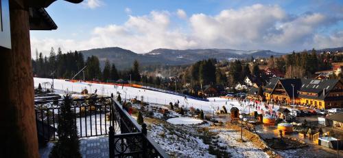 a group of people on a snow covered ski slope at Apartamenty Złoty Groń in Istebna