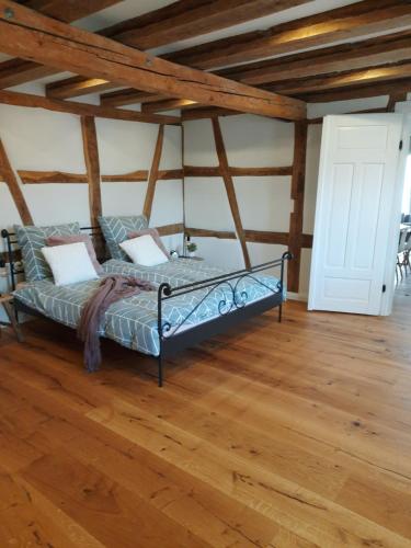 a bed in a room with a wooden floor at BEAS WOHNEN in Sinsheim