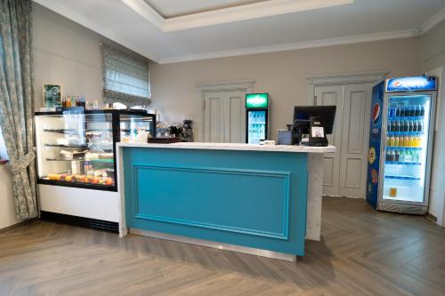 a store with a blue counter and a refrigerator at Pensjonat Dominikański in Krasnobród