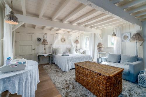 Guesthouse B&B De Loverlij في جابيكي: غرفة نوم بسريرين واريكة وطاولة