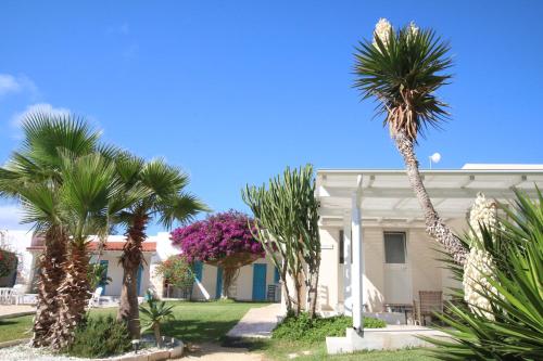 a house with palm trees in front of it at Antichi Mulini in Favignana