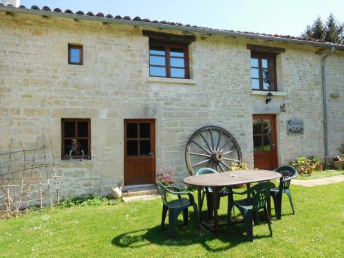 a table and chairs in front of a building at Chatenet self catering stone House for 2 South West France in Limalonges