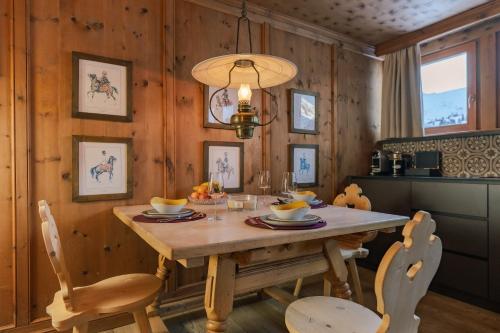 a dining room with a wooden table and chairs at Hotel Jagdschloss Resort in Kühtai