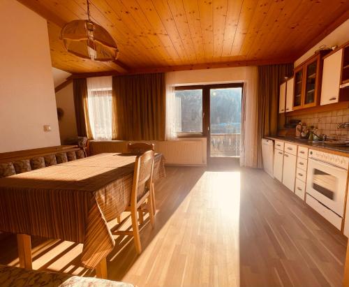 a kitchen with a large wooden table in a room at Alpenpension Gasthof in Ratten