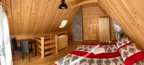 a bedroom in a log cabin with a bed and a desk at Tatra Break in Witów