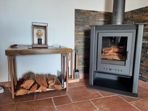 a living room with a fireplace and a wood stove at Herdade de Vale Maceiras in Santiago do Cacém