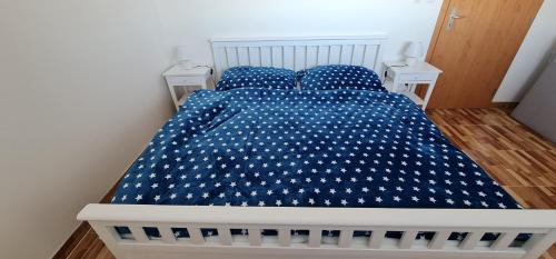 a bed with a blue bedspread with stars on it at Domček 22 in Dudince