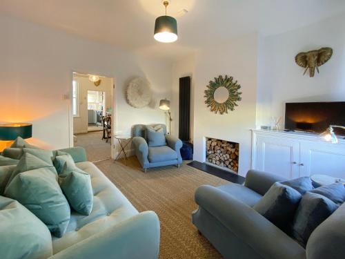 a living room with a couch and a fire place at 3 Chestnut Terrace, Long Melford in Long Melford