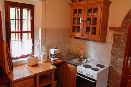 a kitchen with a white stove and a sink at Cserépmadár szállás és Csinyálóház in Velemér