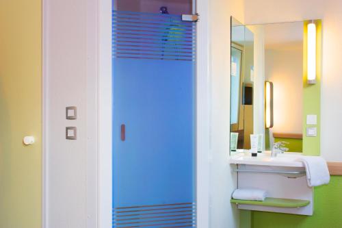 uma casa de banho com um lavatório e um espelho em Hôtel Ibis Budget Nantes Nord St Herblain em Saint-Herblain