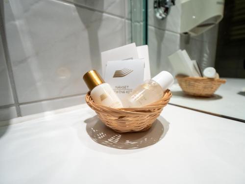 a basket with two bottles of soap in a bathroom at Hotel Erbprinz & Restaurant "Prinzenstube" in Ludwigslust